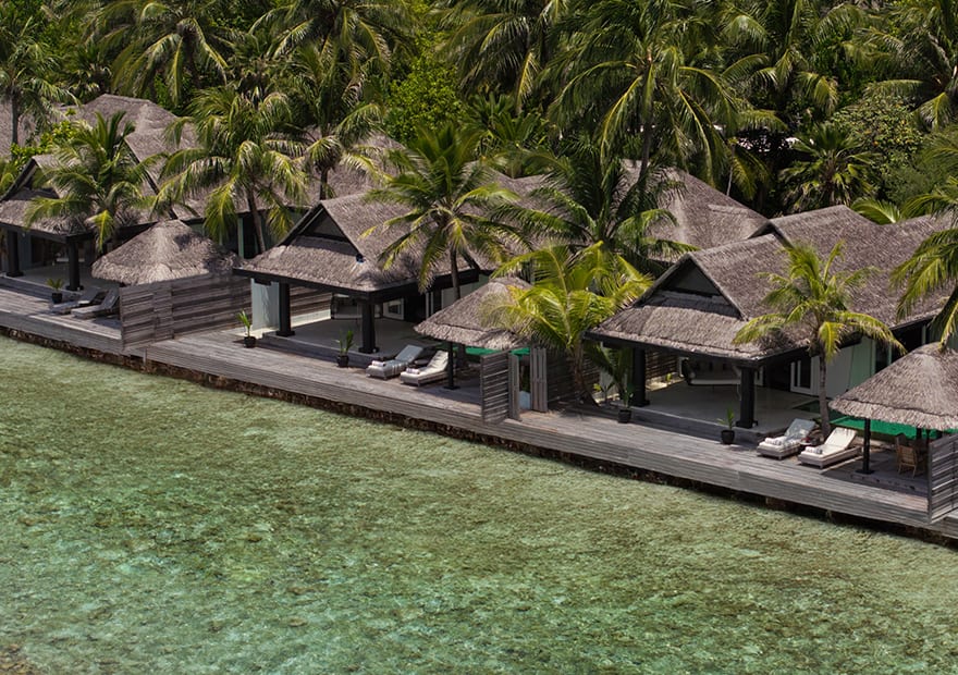 Aerial view of ocean houses lined along the lagoon at Naladhu Private Island Maldives