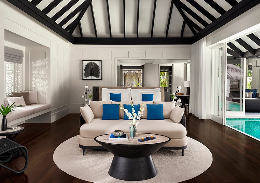 Spacious villa interior featuring stylish seating and tropical surroundings at Naladhu Private Island Maldives.