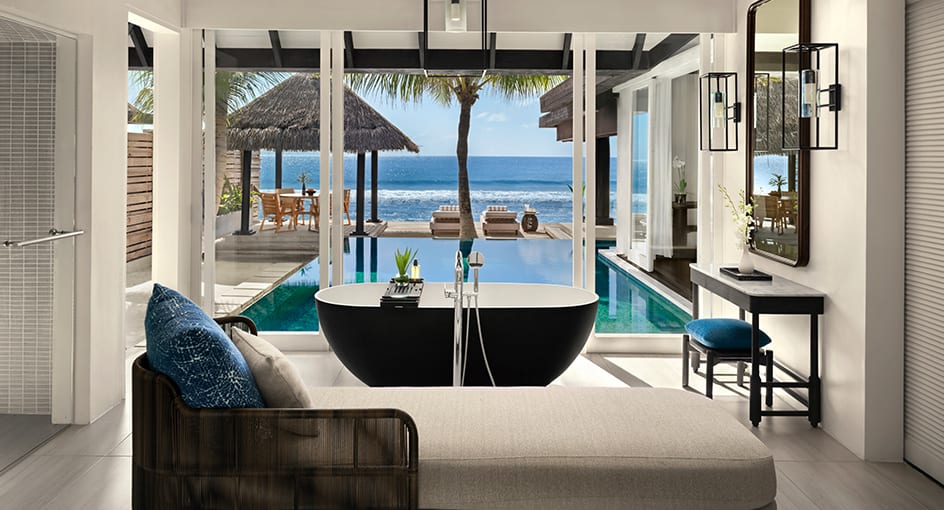 Luxurious bathroom with freestanding bathtub and private pool overlooking the ocean at Naladhu Private Island Maldives.