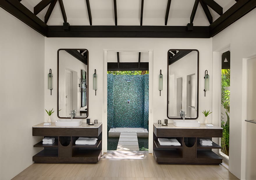 Luxury bathroom with dual vanities and outdoor shower at Naladhu Private Island Maldives.