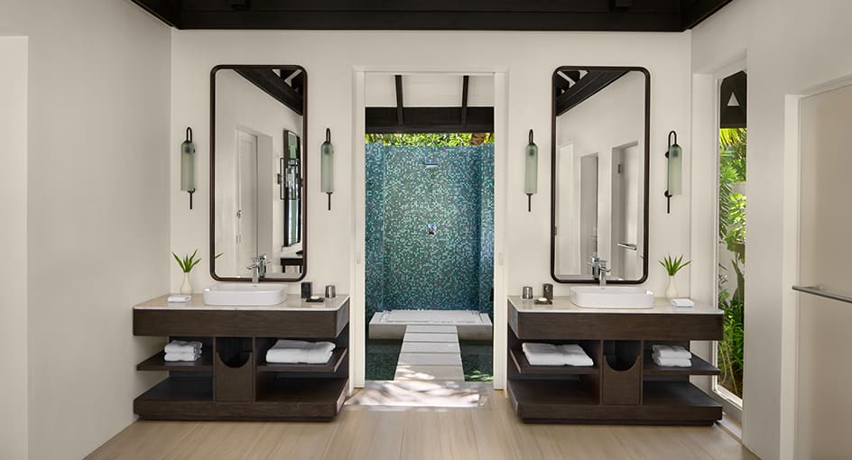 Luxury bathroom with dual vanities and outdoor shower at Naladhu Private Island Maldives.