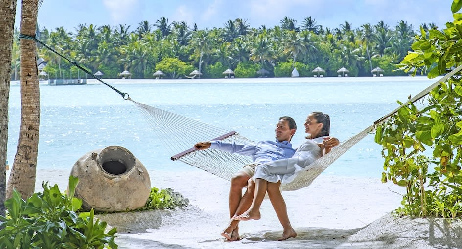 Couple sitting on the beach at Naladhu Maldives