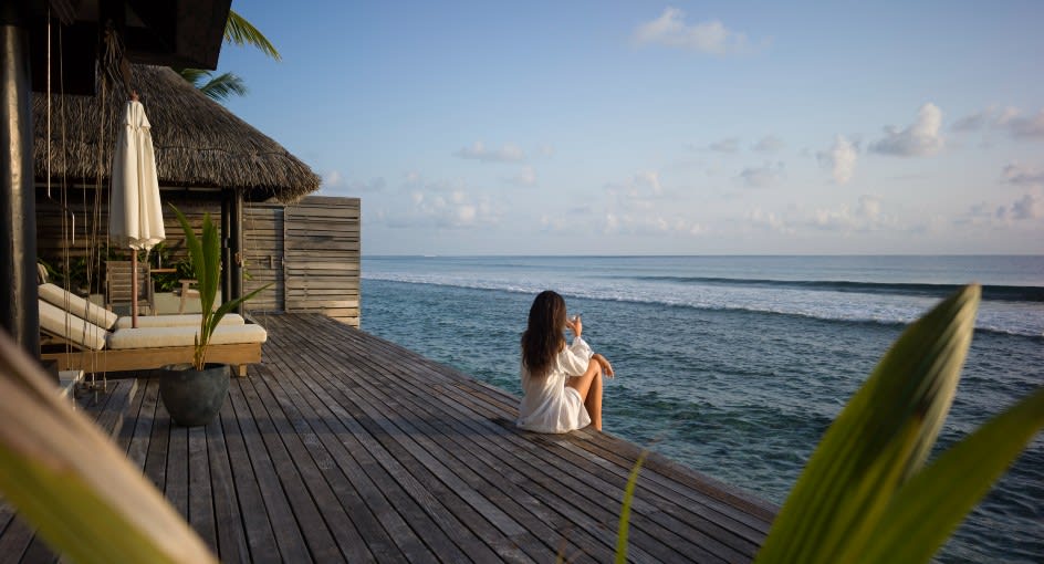 Guest enjoying the ocean breeze and view from Ocean House with Pool room at Naladhu Private Islands Maldives