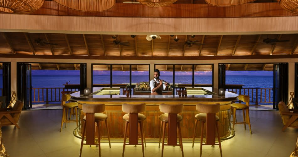 Bartender at the counter of The Yellow Fin Club, an adults-only bar at Anantara Dhigu Maldives Resort