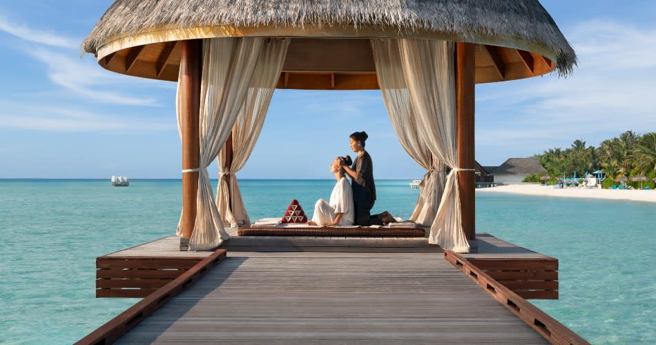 Guest enjoying treatment on the overwater sala at Anantara Dhigu Maldives Resort