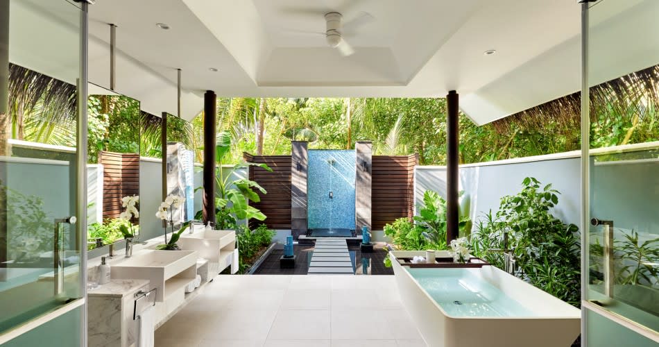 Open-air bathroom in the Deluxe Beach Pool Villa at Niyama Private Islands Maldives, featuring soaking tub, rain shower, and tropical garden views