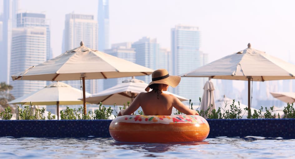 Lady in the pool in a floaty enjoying the sunset views on the pool