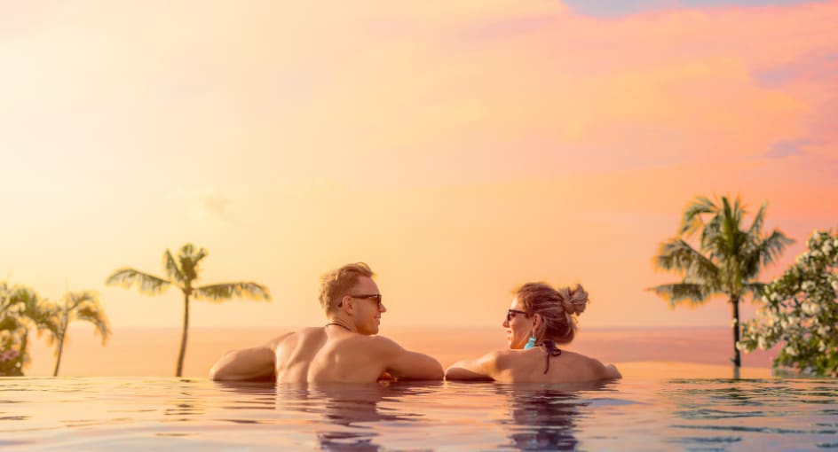 A couple looking at the sunset from the infinity pool at NH Bentota Ceysands Resort