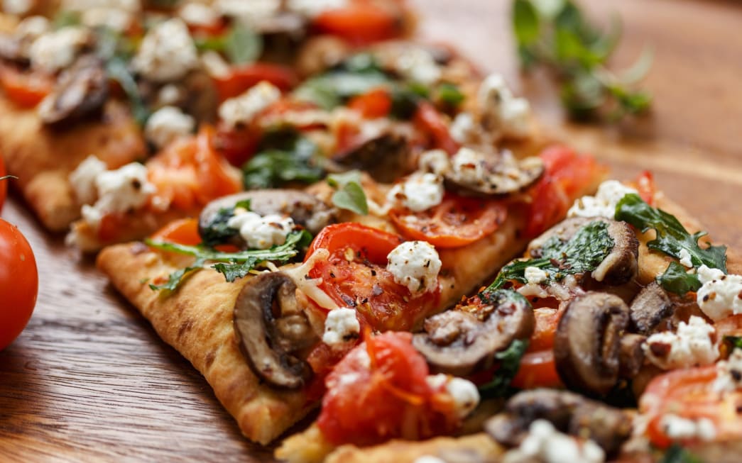 Freshly flatbread pizza topped with vegetables and cheese at NH Collection Maldives Reethi 