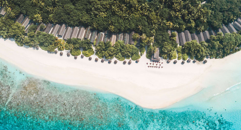 Aerial view of beachfront villas and turquoise lagoon at NH Collection Maldives Reethi Resort – All-Inclusive Maldives offer