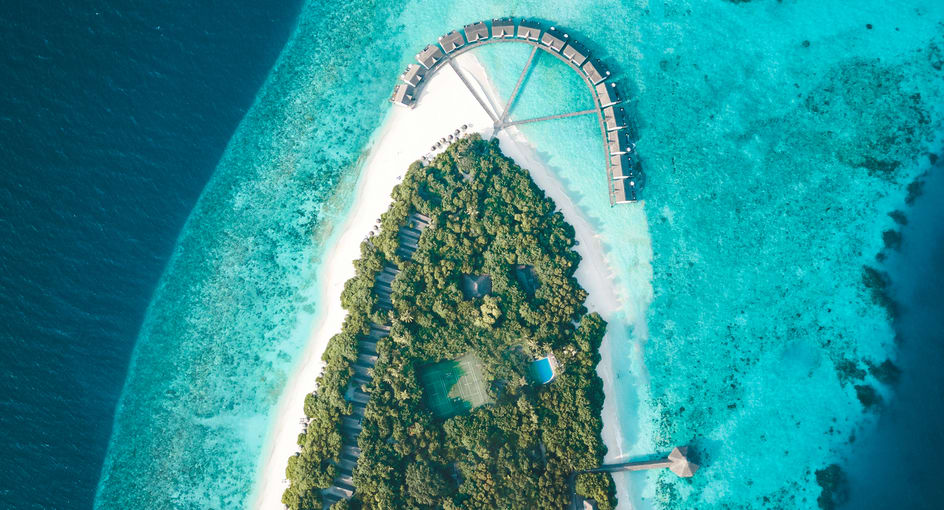 NH Collection Maldives Reethi Beach aerial view with lush island, white sand beach, and lagoon – Flash Sale Maldives resort offer.