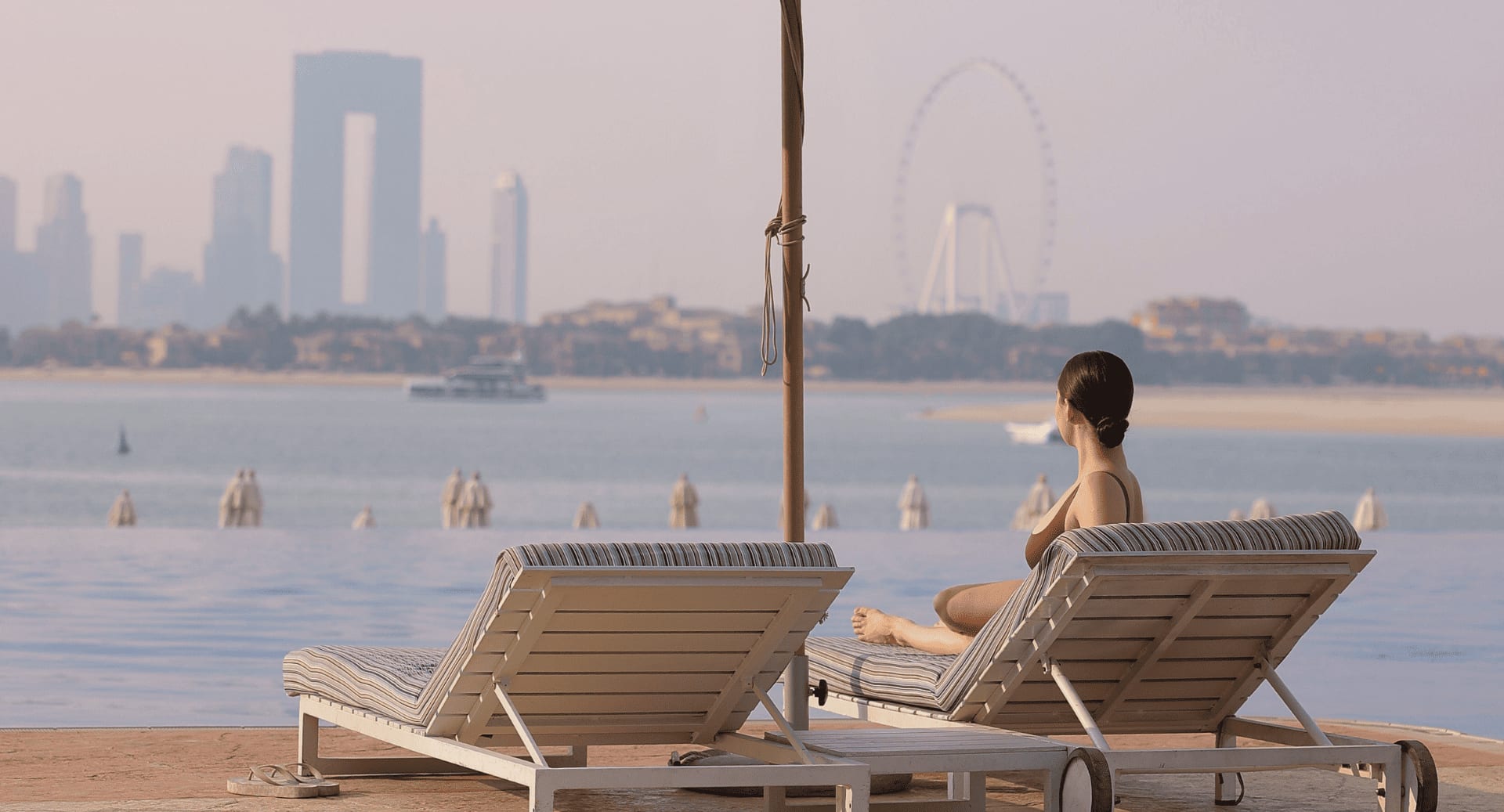 lady in a sunbed enjoying the view from the infinity pool