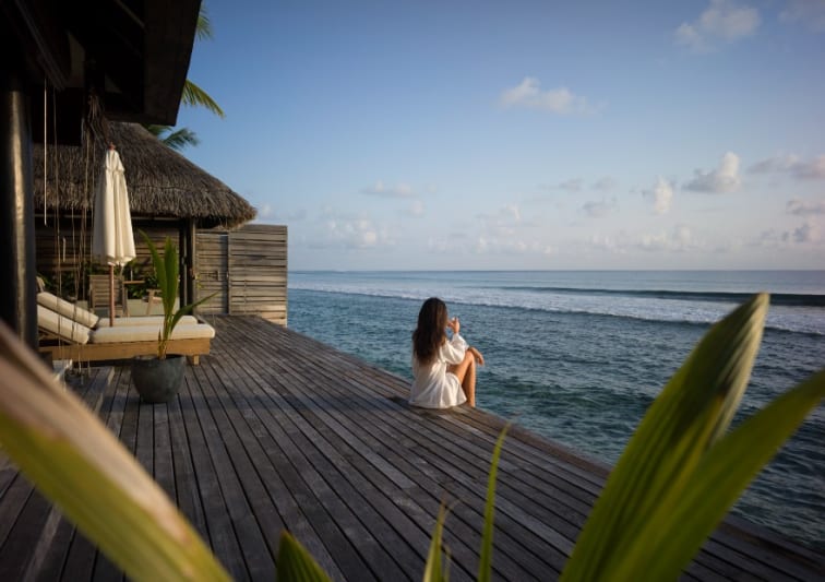 Guest enjoying the ocean breeze and view from Ocean House with Pool room at Naladhu Private Islands Maldives