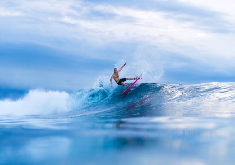 Surfer riding a wave near Naladhu Private Island Maldives