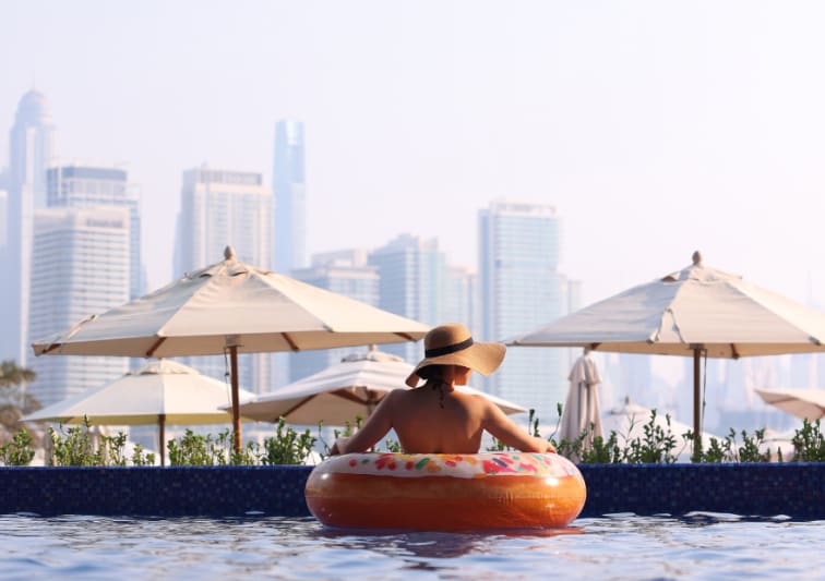 Lady in the pool in a floaty enjoying the sunset views on the pool