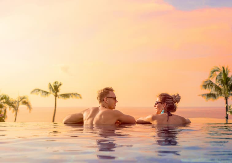 A couple looking at the sunset from the infinity pool at NH Bentota Ceysands Resort