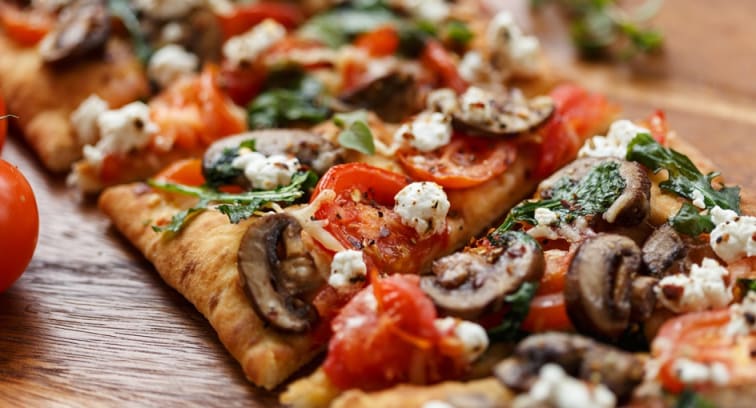 Freshly flatbread pizza topped with vegetables and cheese at NH Collection Maldives Reethi 