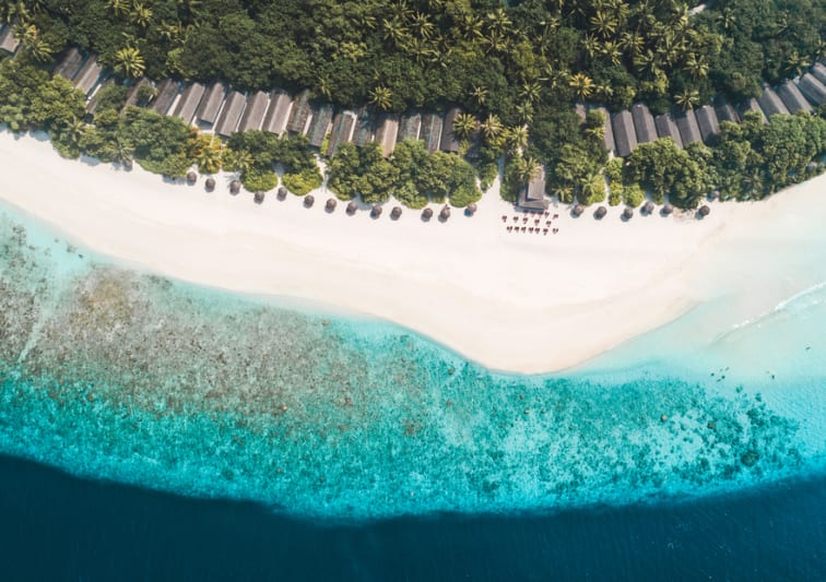 Aerial view of beachfront villas and turquoise lagoon at NH Collection Maldives Reethi Resort – All-Inclusive Maldives offer