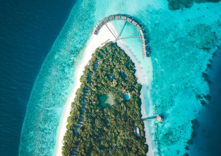 NH Collection Maldives Reethi Beach aerial view with lush island, white sand beach, and lagoon – Flash Sale Maldives resort offer.