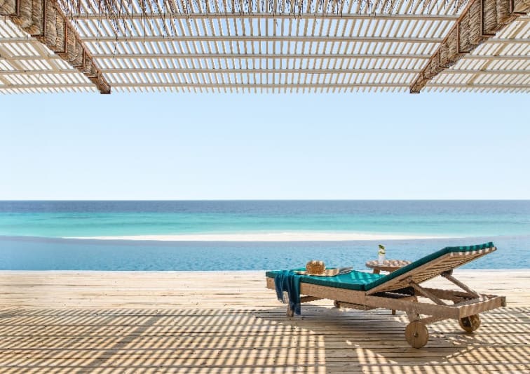 Beachfront sun loungers at NH Collection Maldives Reethi Beach overlooking the turquoise Indian Ocean