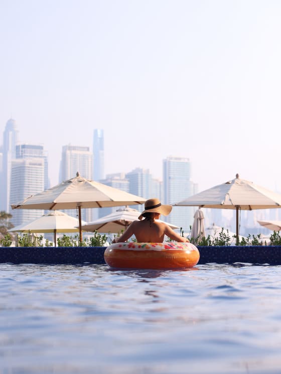 Lady in the pool in a floaty enjoying the sunset views on the pool