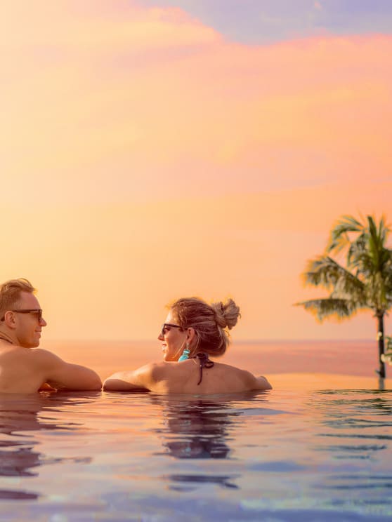 A couple looking at the sunset from the infinity pool at NH Bentota Ceysands Resort