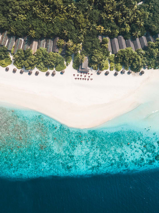 Aerial view of beachfront villas and turquoise lagoon at NH Collection Maldives Reethi Resort – All-Inclusive Maldives offer