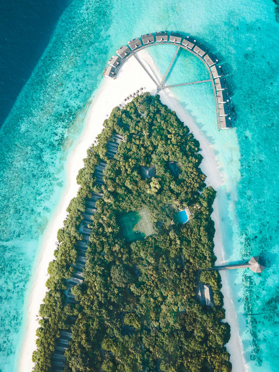 NH Collection Maldives Reethi Beach aerial view with lush island, white sand beach, and lagoon – Flash Sale Maldives resort offer.