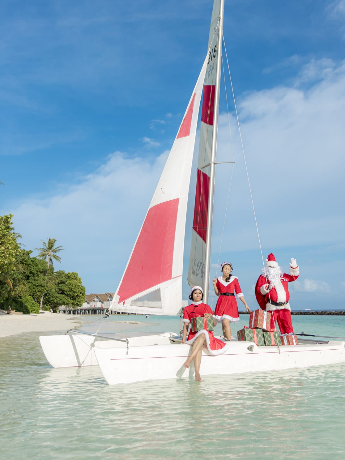 Santa and festive helpers arriving by sailboat with gifts at NH Maldives Kuda Rah Resort