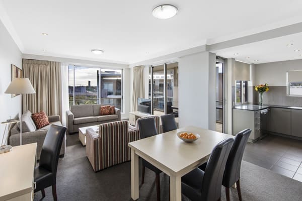 spacious living room area with modern furniture and large windows in Bowen Hills 3 bedroom apartment