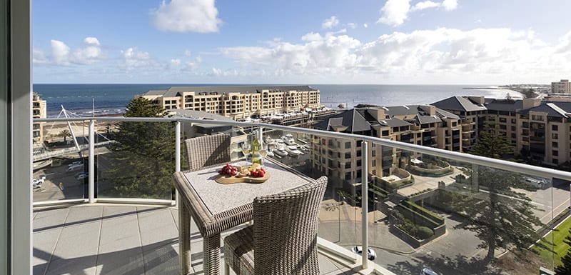 Glenelg hotels with vegan meal options on table on big balcony of 3 bedroom apartment with views of ocean and Glenelg beach in South Australia