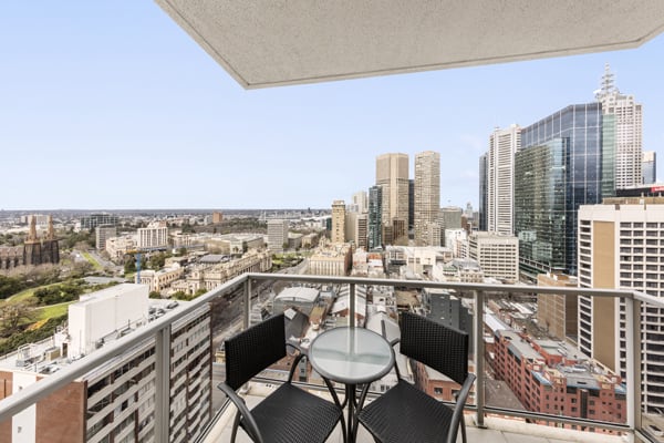 3 Bedroom Apartment private balcony with vegan meal from lunch menu on table and views of Melbourne CBD at Oaks On Lonsdale hotel